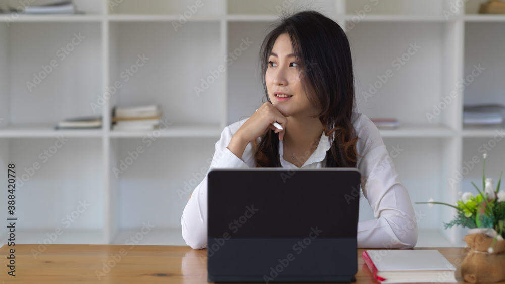 Female business worker working with tablet while looking out at the windows Female business worker working with tablet while looking out at the windows