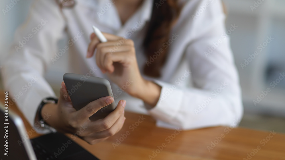 Businesswoman using her smartphone in the office room Businesswoman using her smartphone in the office room