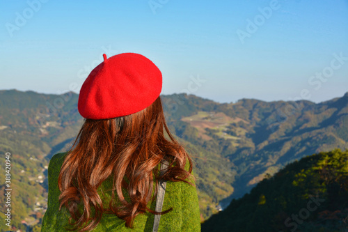 秋の紅葉の風景を眺める女性