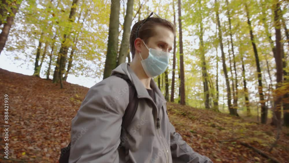 Male influencer shooting video hiking down the hill wearing face mask 4K Male influencer shooting video hiking down the hill wearing face mask 4K