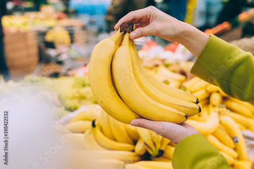 Girl holding a bunch of bananas in the supermarket.