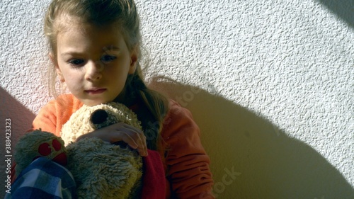 Mistreated child. Little girl on the floor sad. Child abuse concept.