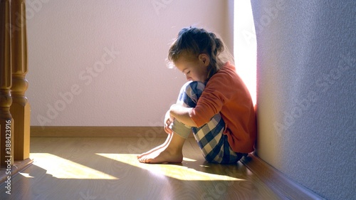 Mistreated child. Little girl on the floor sad. Child abuse concept.