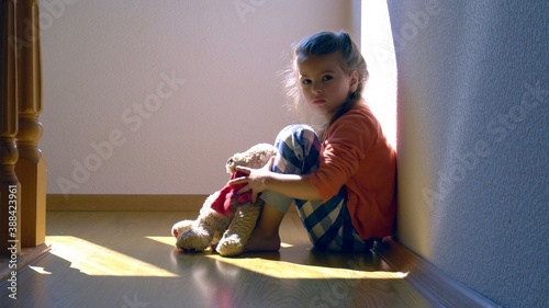Mistreated child. Little girl on the floor sad. Child abuse concept.