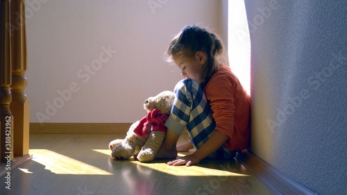 Mistreated child. Little girl on the floor sad. Child abuse concept.