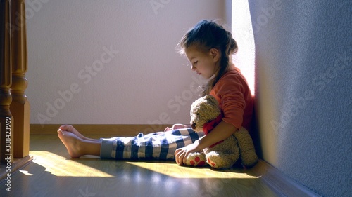 Mistreated child. Little girl on the floor sad. Child abuse concept.