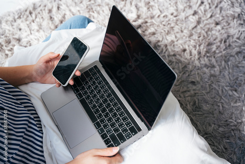 Business man working with laptop and smartphone on white pillow.