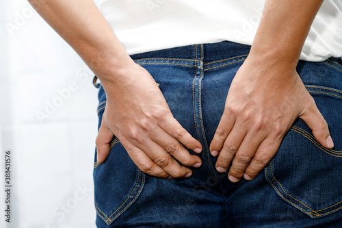 Man with hemorrhoids holding his butt in pain because having abdominal constipation and itching in the anus or anorectal abscess, Health care concept. 
