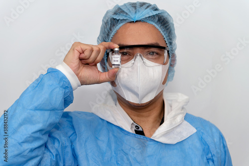 Coronavirus covid 19 disease expert hold samples of coronavirus covid 19 vaccine sample labelled coronavirus covid 19 with confidence and protective suit, mask and gloves