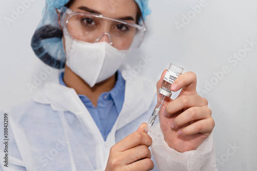 Coronavirus covid 19 disease expert hold samples of coronavirus covid 19 vaccine sample labelled coronavirus covid 19 with confidence and protective suit, mask and gloves