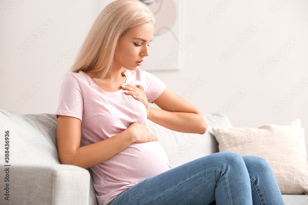 Young pregnant woman touching her breast at home Young pregnant woman touching her breast at home