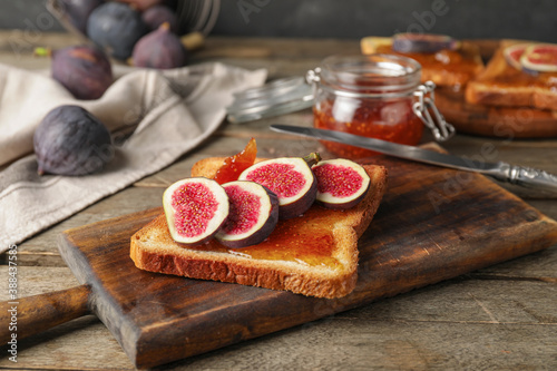 Tasty sandwich with sweet fig jam on table