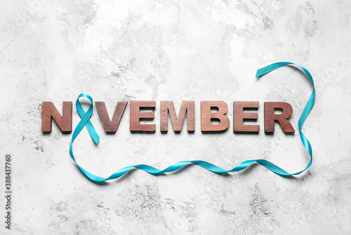 Blue ribbon and word NOVEMBER on light background. Prostate cancer awareness concept