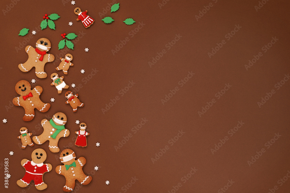 Fototapeta premium Merry christmas and happy new year greeting card with gingerbread mask man cookies on brown background. Flay lay ,top view, copy space.マスクをつけたジンジャーマンクッキー