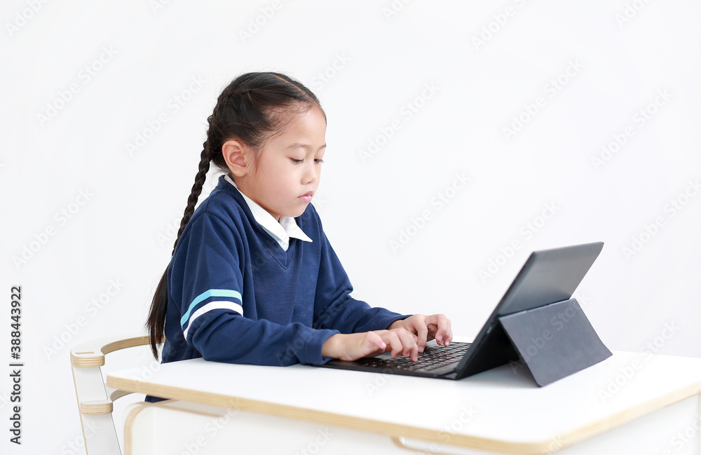 Portrait asian little child girl in school uniform using laptop on table isolated on white background, Studio shot Portrait asian little child girl in school uniform using laptop on table isolated on white background, Studio shot