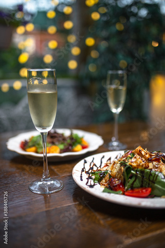 meat with potatoes and champagne on a wooden table