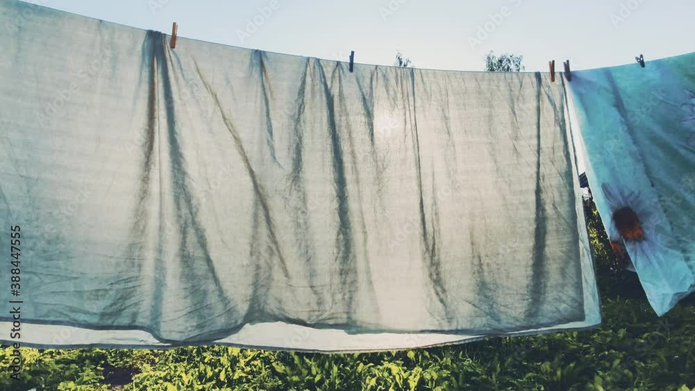 Colorful laundry hanging on the rope outdoors. The process of air drying clothes