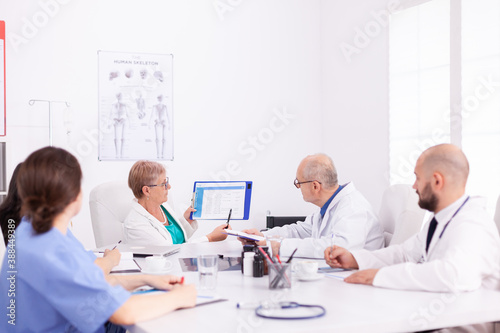 Experienced doctors in hospital meeting room working together during health seminar. Clinic expert therapist talking with colleagues about disease, medicine professional