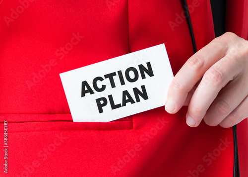 Business concept. Businessman holds a card with the text - ACTION PLAN, puts it in his kars jacket pocket