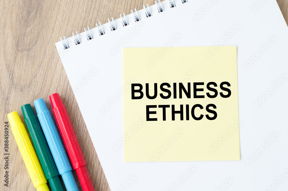 Business Ethics inscription on a notebook on an office table, next to lie colored markers. Business Ethics inscription on a notebook on an office table, next to lie colored markers.