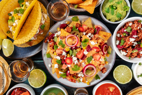 Mexican food, a table with many various colorful dishes, shot from above on a dark blue wooden background
