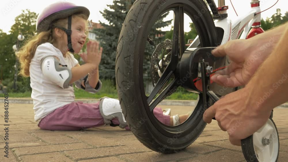 Child bike training wheels. Father teaches his child to ride without training wheels, removing
