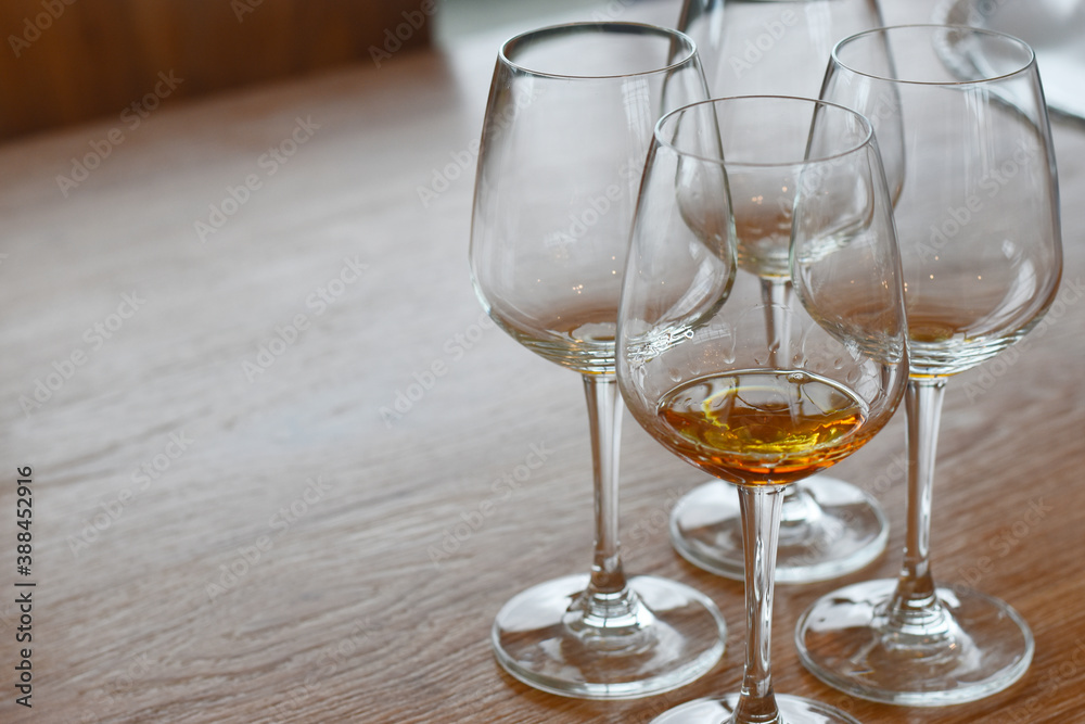 There is a glass of wine in the bottom of the glass. Put on the table, wood grain, brown There is a glass of wine in the bottom of the glass. Put on the table, wood grain, brown