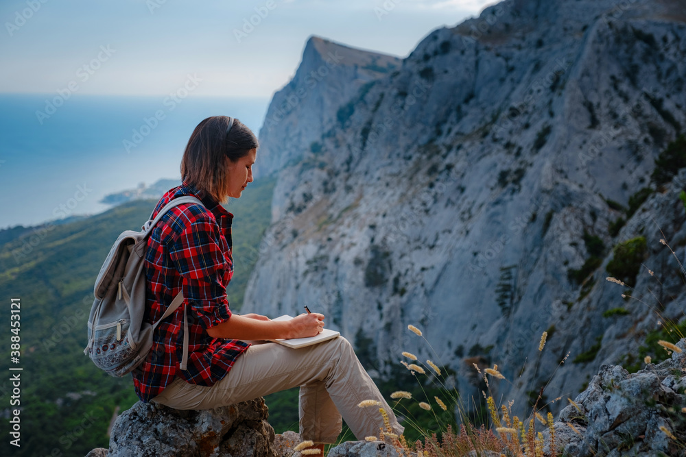 Naklejka premium woman hiker enjoy the view at sunset mountain peak cliff