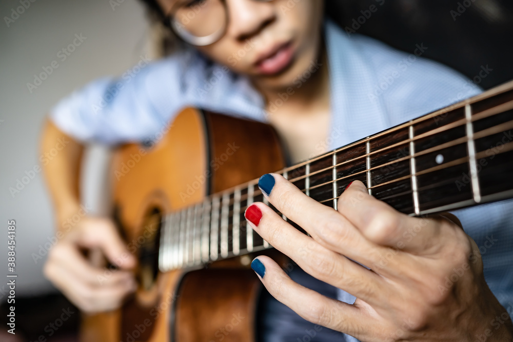A man with polished nails playing guitar