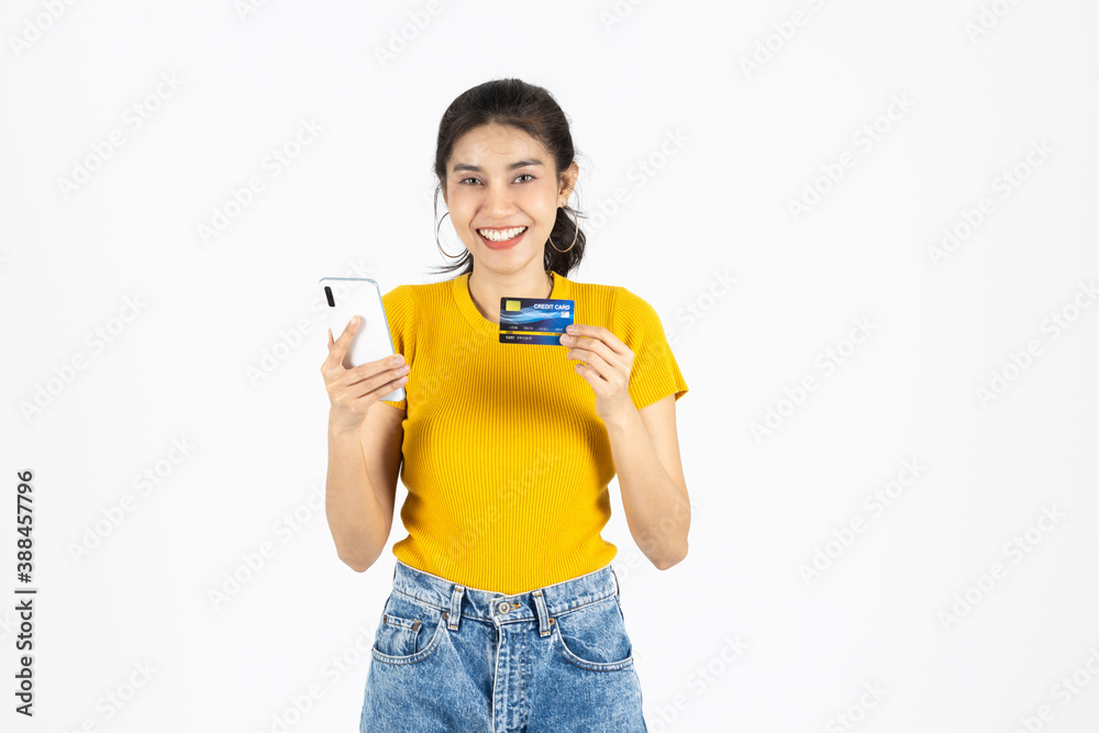 Attractive young Asian woman holding mobile smart phone and credit card on white isolated background. Shopping online concept. Attractive young Asian woman holding mobile smart phone and credit card on white isolated background. Shopping online concept.