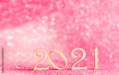 Numbers of new year 2021 on a pink shiny glitter background. Festive christmas background. Selective focus