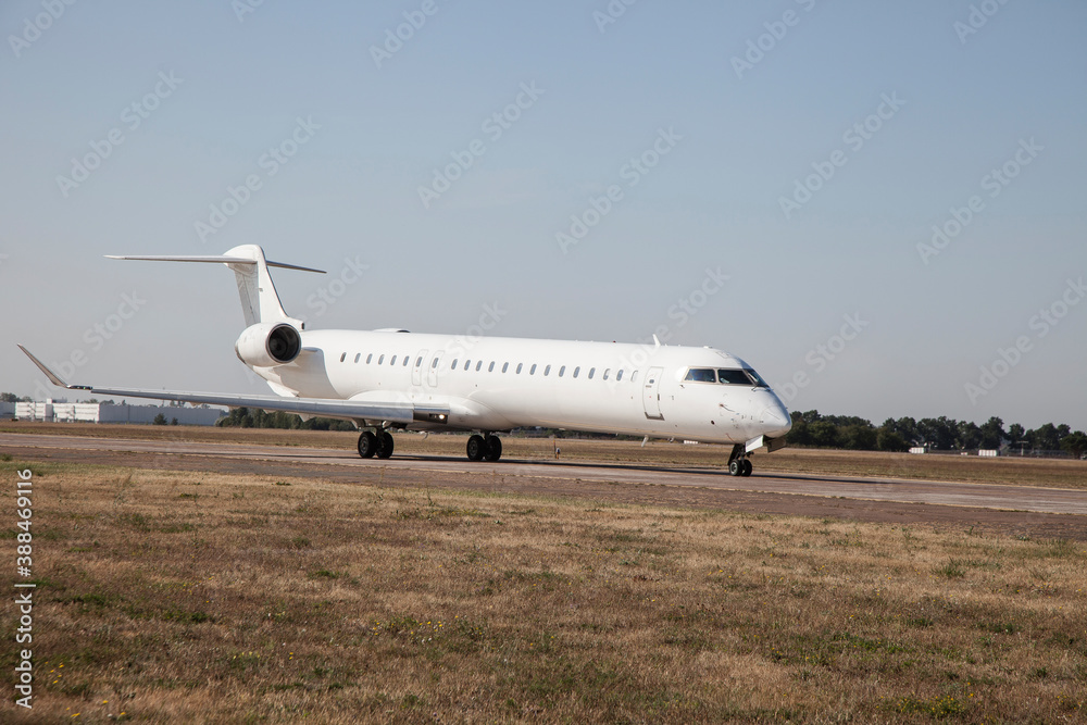 A white plane on the airport runway is taxiing. Takeoff and landing. Arrival and departure. Place for text. Passenger plane isolated mockup. Airplane flights. Travel by air transport. Copy space. A white plane on the airport runway is taxiing. Takeoff and landing. Arrival and departure. Place for text. Passenger plane isolated mockup. Airplane flights. Travel by air transport. Copy space.