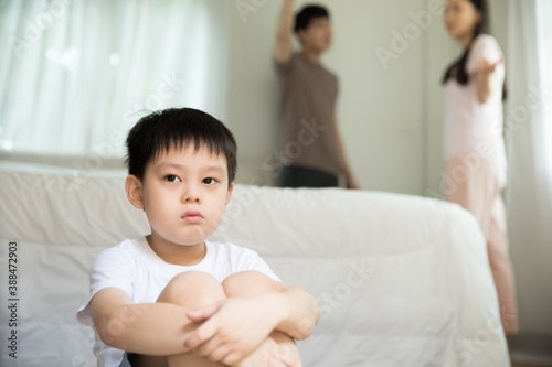 Little boy with boring expression while listening to his parents' fighting