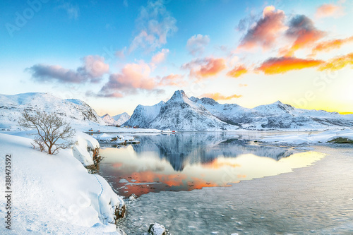 Fantastic frozen Flakstadpollen and Boosen fjords and reflection in water during sunrise with Hustinden mountain on background on Flakstadoya island photo