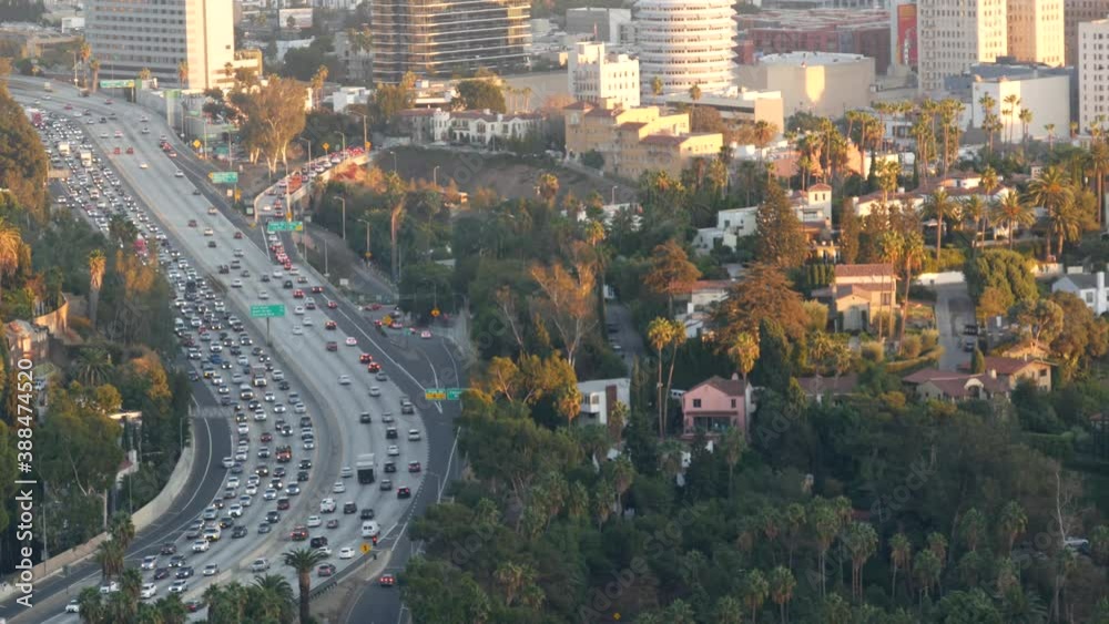 Busy rush hour intercity highway in metropolis, Los Angeles, California USA. Urban traffic jam on road in sunlight. Aerial view of cars on multiple lane driveway. Freeway with automobiles in LA city.