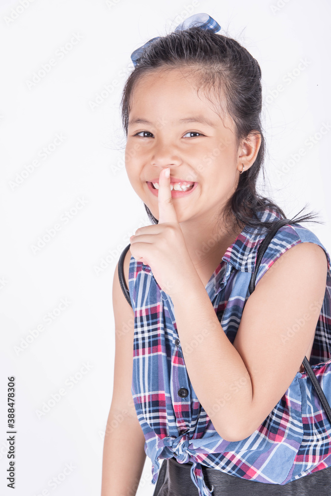 Portrait of cute casual smiling asian girl 8-9 year old posing and looking at camera isolated on light background. Positive emotions. Keep Silence Concept. Cheerful asian child putting finger on lips. Portrait of cute casual smiling asian girl 8-9 year old posing and looking at camera isolated on light background. Positive emotions. Keep Silence Concept. Cheerful asian child putting finger on lips.