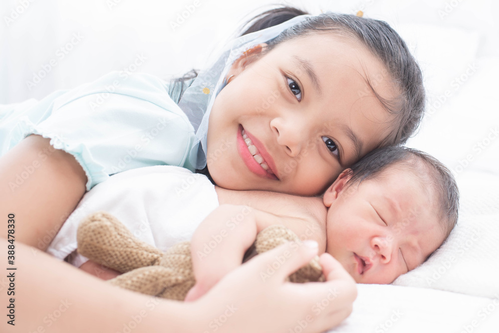 little sister hugging her newborn brother. toddler kid meeting new sibling. love, trust and tenderness. cute girl and new born baby boy relax in a white bedroom. family with children at home. little sister hugging her newborn brother. toddler kid meeting new sibling. love, trust and tenderness. cute girl and new born baby boy relax in a white bedroom. family with children at home.