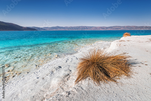 Panoramic view of the white sandy beach with grass bushes on the famous lake Salda in Turkey. Wonders of nature and turkish maldives concept