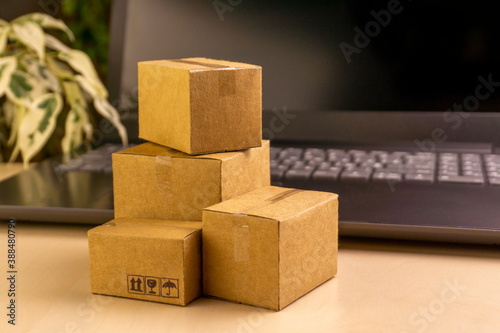 online shopping concept. little deliver boxes, smartphone, shopping bags, shopping bascket stand on laptop. copy space