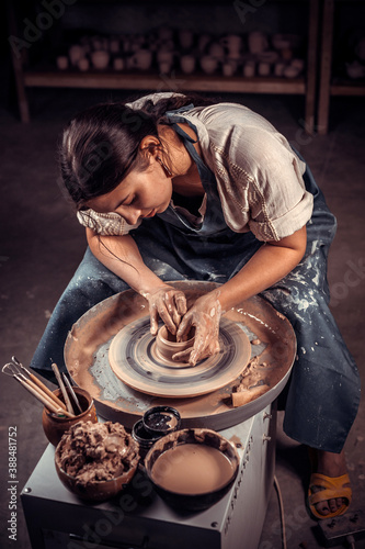 Charming pottery master making ceramic pot on the pottery wheel . Ceramics art concept .