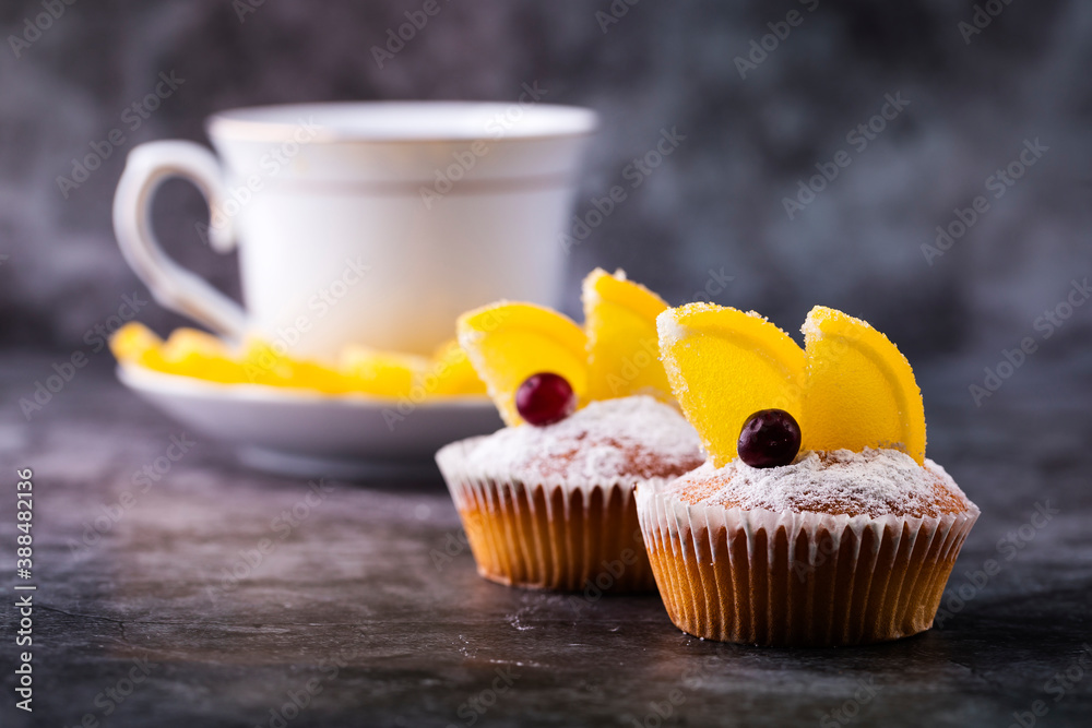 Cupcakes with slices of marmalade and cranberries on a gray background. Cupcakes with slices of marmalade and cranberries on a gray background.