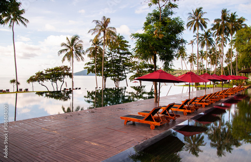 Infinity edge pool under blue sky in summer with beach umbrellas photo
