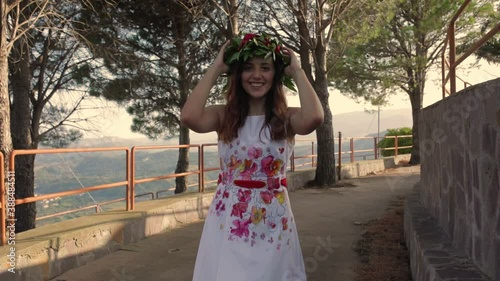 Giovane ragazza con vestito bianco si laurea. Corona di alloro in testa simbolo trionfale italiano. photo