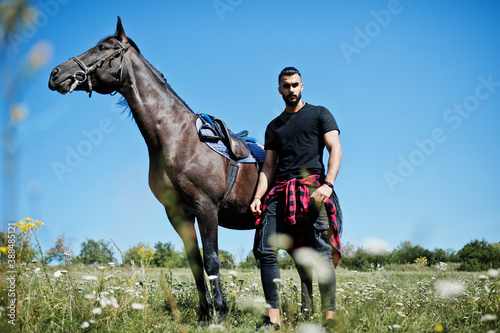 Arab tall beard man wear in black with arabian horse. © AS Photo Family