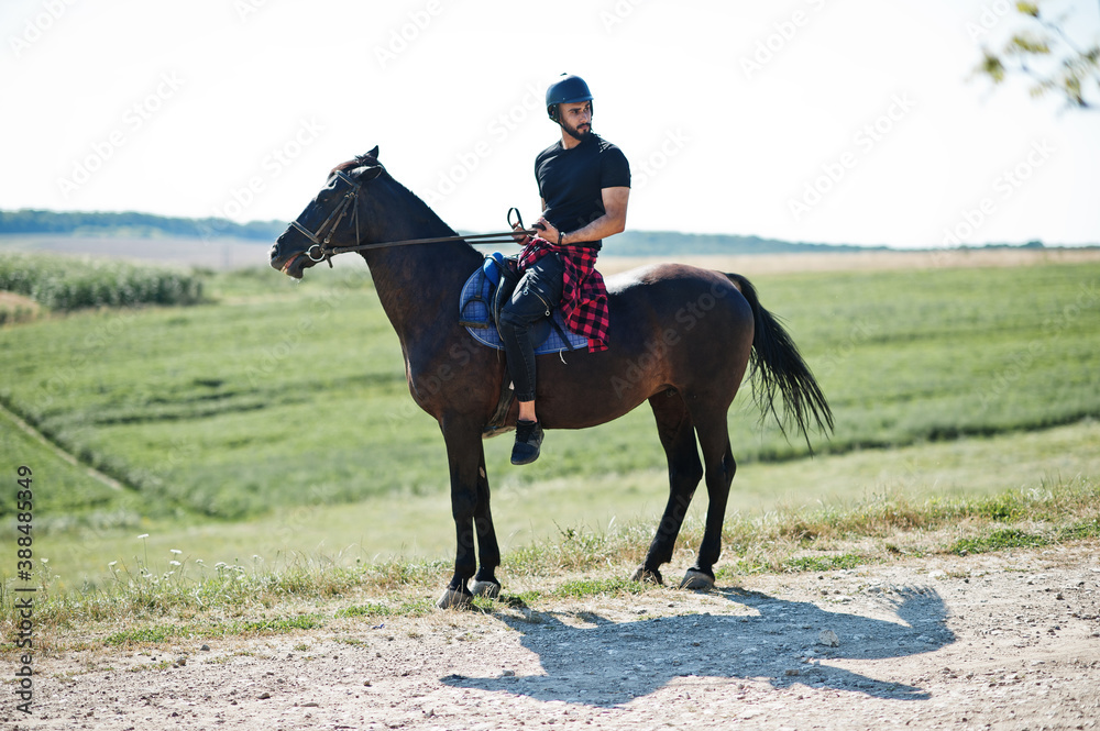 Arab tall beard man wear in black helmet, ride arabian horse. Arab tall beard man wear in black helmet, ride arabian horse.