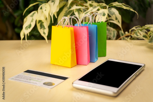 online shopping concept. little deliver boxes, smartphone, shopping bags, shopping bascket stand on laptop. copy space