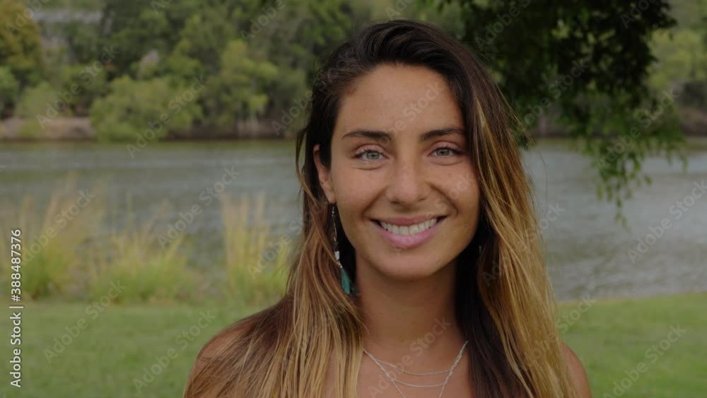Beautiful Tanned Woman Smiling While Looking At Camera By The Lake - Gold Coast, Queensland, Australia. - close up shot Beautiful Tanned Woman Smiling While Looking At Camera By The Lake - Gold Coast, Queensland, Australia. - close up shot