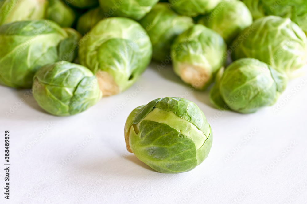 Closeup of green brussels sprouts with one in focus on white background. Closeup of green brussels sprouts with one in focus on white background.