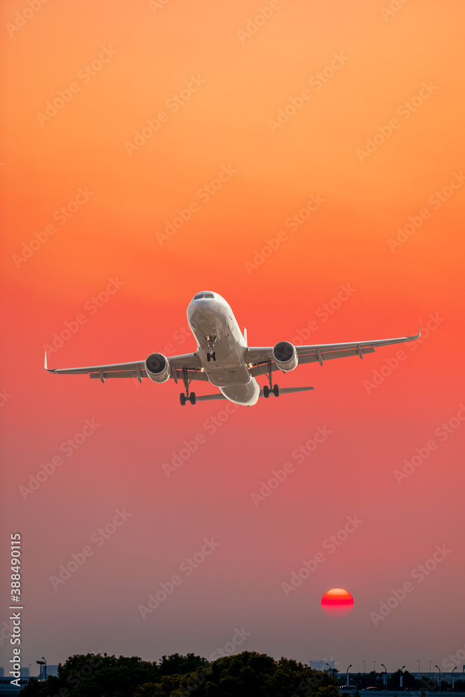 Commercial airplane flying above clouds in colorful sunset.Travel,holidays and business concept.