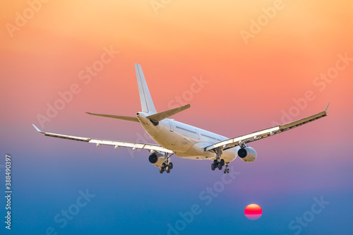 Commercial airplane flying above clouds in colorful sunset.Travel holidays and business concept.